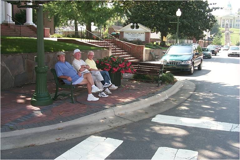 three elderly men sitting on a bench